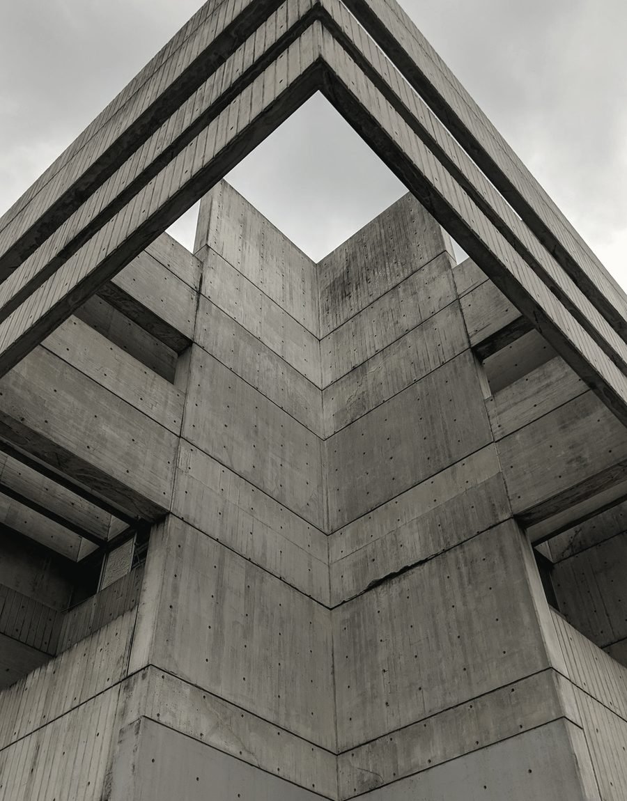 Concrete structural forms converging on a single vertex.